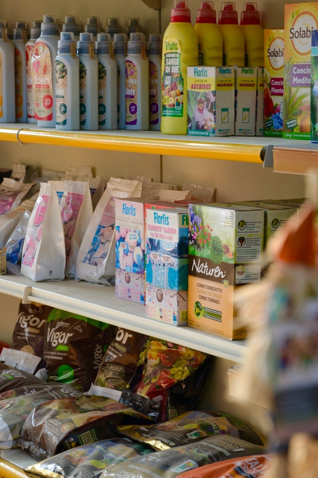 Scaffale con concimi, fertilizzanti e sacchi di terriccio di diverse marche